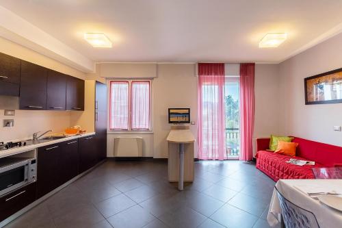 una cucina e un soggiorno con divano rosso di Appartamenti Linda a San Bartolomeo al Mare