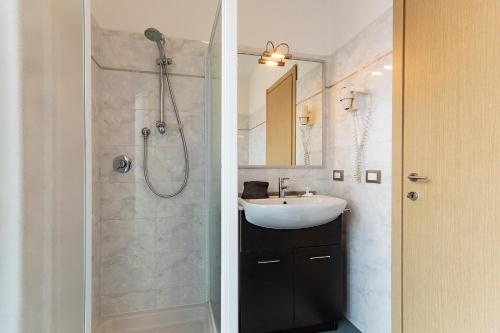 een witte badkamer met een wastafel en een douche bij Appartamenti Linda in San Bartolomeo al Mare