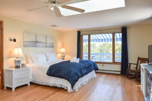 Un dormitorio con una cama y una ventana grande. en Steps to Private Association Beaches, en Eastham