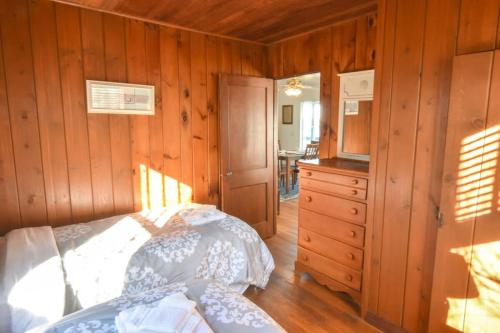 a bedroom with a bed and a wooden wall at Waterfront amazing views near beaches in Eastham