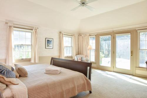- une chambre avec un grand lit et des fenêtres dans l'établissement Walk to Water Hot Tub & Game Room, à Eastham