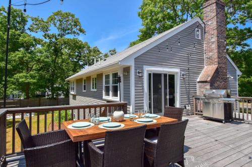 a patio with a table and chairs on a deck at Minutes to Private Association in Eastham