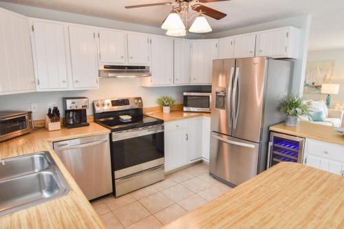 a kitchen with stainless steel appliances and white cabinets at Minutes to Private Association in Eastham