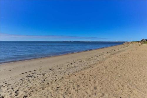 a beach with footprints in the sand and water at Minutes to Private Association in Eastham