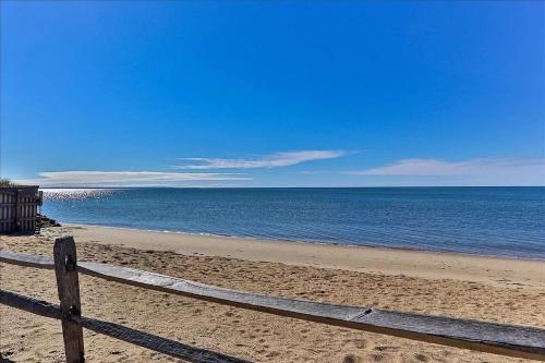 a wooden fence on a beach near the ocean at Minutes to Private Association in Eastham