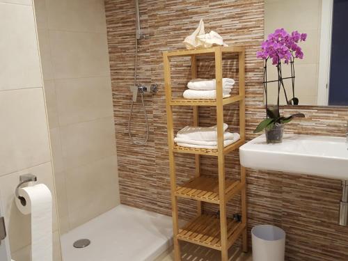 a bathroom with a bamboo towel rack next to a sink at Mandala apARTments in Calafell