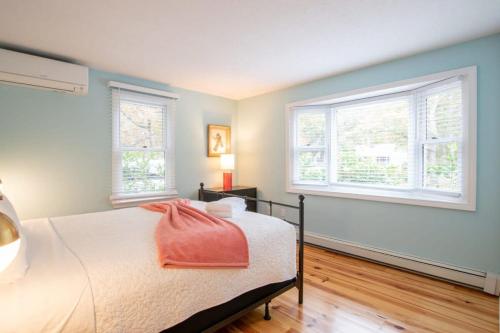 a bedroom with a bed and two windows at Sunroom Expansive Patio Fenced Yard in Eastham