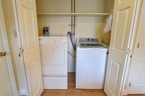 a small kitchen with a stove and a washer at Sunroom Mins to Beaches Views of Marsh in Eastham