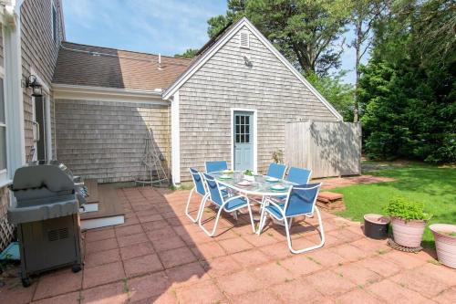 a patio with a table and chairs and a grill at Sunroom Mins to Beaches Views of Marsh in Eastham