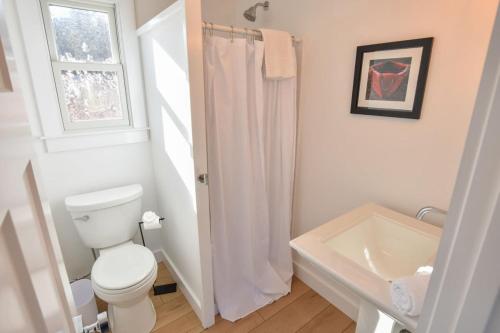 ein weißes Badezimmer mit Toilette und Waschbecken in der Unterkunft Newly Renovated Cottage on Town Cove in Eastham