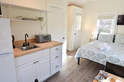 a kitchen with a sink and a bed in a room at Dreamy Cottage for Two Close to Beaches in Eastham