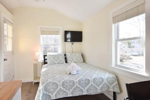 a bedroom with a bed with a stuffed animal on it at Dreamy Cottage for Two Close to Beaches in Eastham