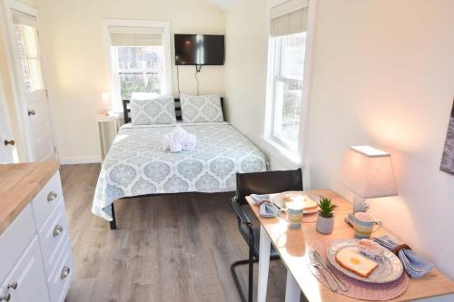 a bedroom with a bed and a table with a breakfast on it at Dreamy Cottage for Two Close to Beaches in Eastham