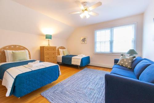 a living room with a blue couch and a bed at 4-5 Min to Mill Pond or Nauset Beach in Orleans