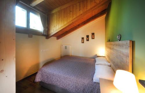 1 dormitorio con cama y ventana en Appartamento Genziana, en Ossana
