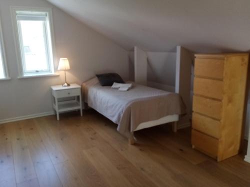 a bedroom with a bed and a dresser and a window at Gula huset in Gothenburg