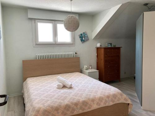 a bedroom with a bed with a white towel on it at Maison à 2 pas de Genève in Ambilly