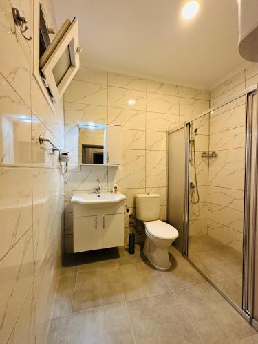 a bathroom with a toilet and a sink and a shower at 9 House in Fethiye