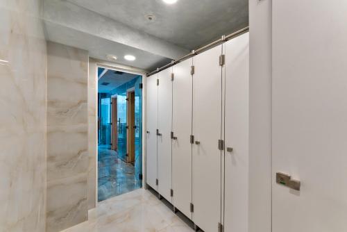 a locker room with white cabinets and a mirror at Golden Panorama Spa & Wellness in Zlatibor