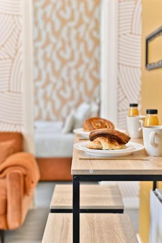 2 assiettes de pain et de viennoiseries sur une table dans l'établissement Appartement Rez-de-chaussée Paris - Montparnasse, à Paris