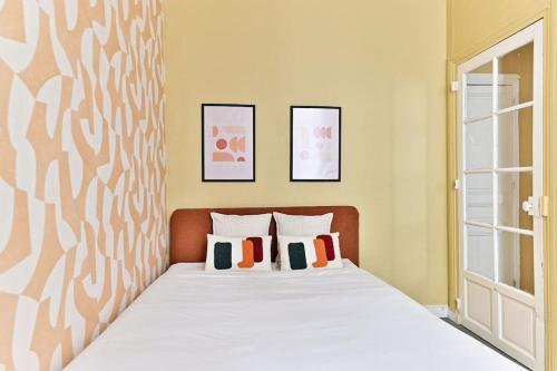 une chambre avec un lit blanc avec deux oreillers dans l'établissement Appartement Rez-de-chaussée Paris - Montparnasse, à Paris