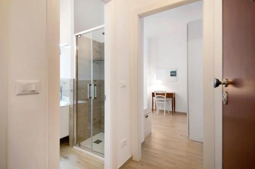 La salle de bains est pourvue d'une douche en verre et d'une table. dans l'établissement Bilocale via Rimembranze 6, à Levanto