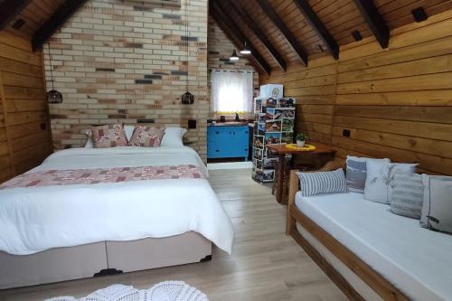 um quarto com duas camas e um sofá em Chalé do Vale Pomerode em Pomerode