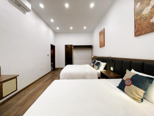 a hotel room with two beds and a tv at Bản Nhỏ - Little Village in Cao Bằng