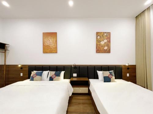 twee bedden in een hotelkamer naast elkaar bij Bản Nhỏ - Little Village in Cao Bằng