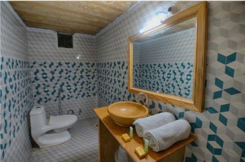 a bathroom with a sink and a toilet and a mirror at Sam Safari Resort Jaisalmer in Jaisalmer