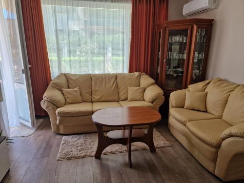 een woonkamer met een bank en een tafel bij Морските Апартаменти на НИКО in Nesebar