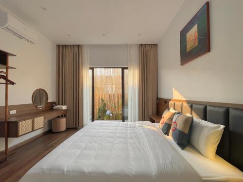 a bedroom with a large bed and a window at Bản Nhỏ - Little Village in Cao Bằng