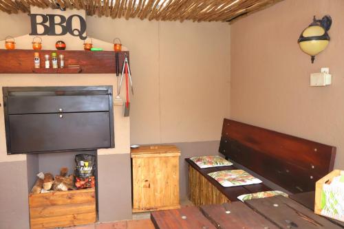 a living room with a large television and a table at The Leopard Tree in Polokwane