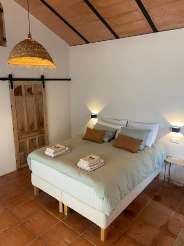 1 dormitorio con 1 cama con 2 toallas en La colina buena - Eco retreat, en Monda
