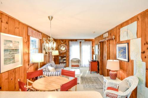a living room with wooden walls and a table and chairs at 2 mins from Nauset Beach in Orleans