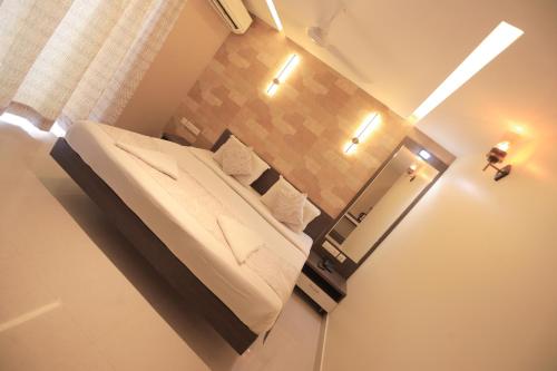 Hotel Shoolin Grand في منغالور: غرفة نوم صغيرة مع سرير ومرآة