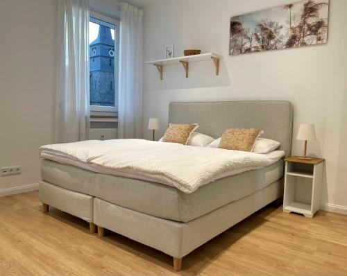 a large bed in a bedroom with a window at Stadtjuwel: Zentral & Modern in Lichtenfels