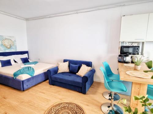 a bedroom with a bed and a blue couch at Mandala - Studiouri si Apartamente in Eforie Nord