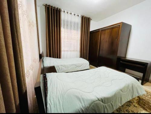 a hotel room with two beds and a piano at Spacious family friendly apartment - Free Barking in Amman