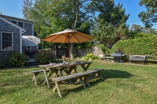 a picnic table with an umbrella and a bench at 1 Mile from Downtown Chatham Walk to Pier in Chatham