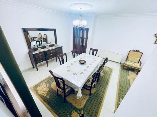 a dining room with a white table and chairs at Spacious family friendly apartment - Free Barking in Amman