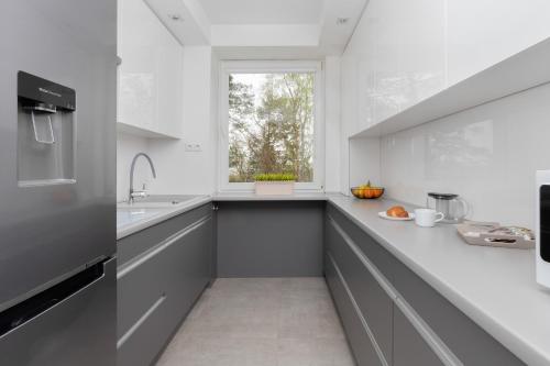a kitchen with white counters and a window at Unique Apartment with a Balcony in Sopot by Rent like home in Sopot