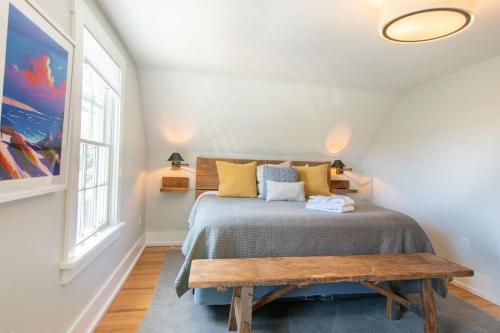 1 dormitorio con cama y banco de madera en Walk to Ryder Cove Wet Bar & Hot Tub, en Chatham