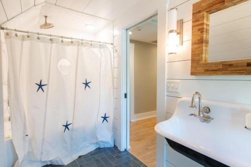 baño con cortina de ducha con estrella de mar azul en Walk to Ryder Cove Wet Bar & Hot Tub, en Chatham