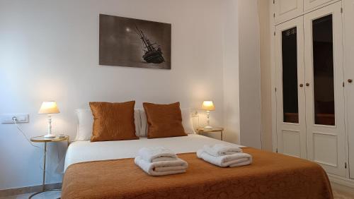 sypialnia z łóżkiem z ręcznikami w obiekcie Sherryflat Torneria- Parking w mieście Jerez de la Frontera