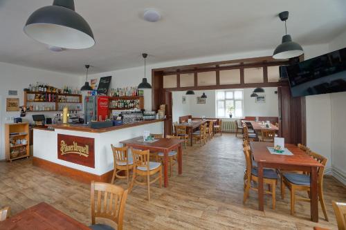 a restaurant with wooden tables and chairs and a counter at Penzion a restaurace na Křižovatce in Polevsko