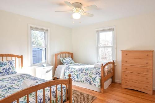 a bedroom with two beds and a ceiling fan at 5-Mins to Forest Beach Dog Friendly in Chatham