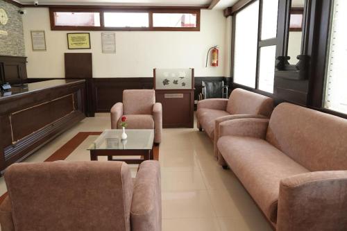 una sala de espera con sofás y mesa de centro en Malanadu Tourist Home, en Hosdrug