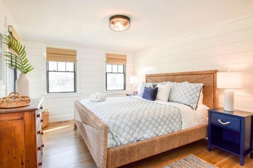 a bedroom with a bed and a table and windows at Gorgeous Home 2 Min Walk to Beach in Harwich