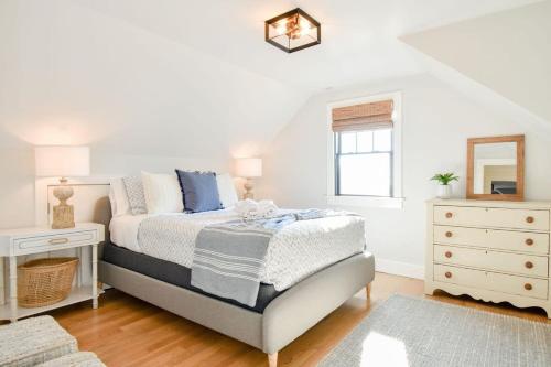 a bedroom with a bed and a dresser and a mirror at Gorgeous Home 2 Min Walk to Beach in Harwich